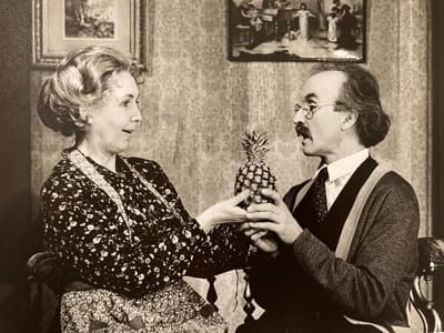 Ett svartvitt foto av en man och en kvinna som håller i en ananas. 