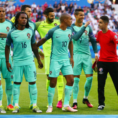 En bollpojke poserar med Portugals herrlandslag i fotboll.