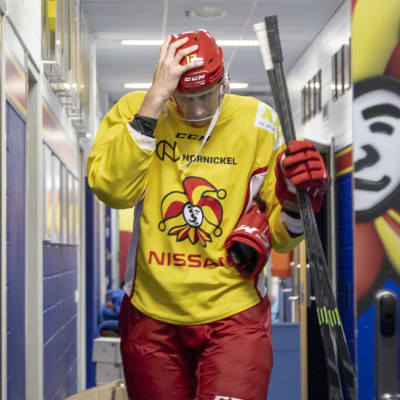 Marko Anttila går genom en korridor i hockeyutrustning.