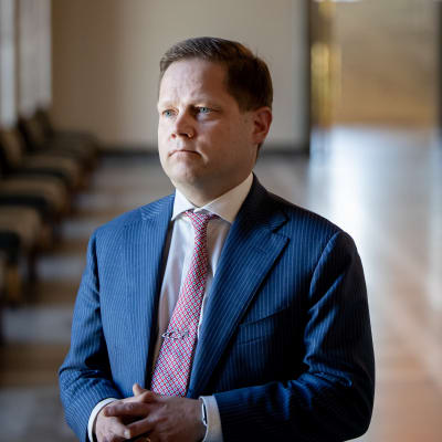 Markus Lohi står i riksdagens korridor och svarar på frågor.  