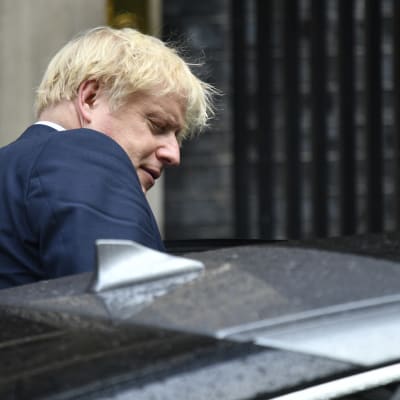 Boris Johnson på väg att stiga in i en bil.