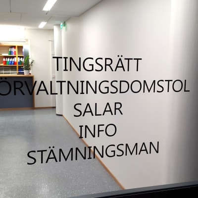 Dörren in till Ålands tingsrätt. På glasdörren står med stora svarta bokstäver tryckt: Tingsrätt, förvaltningsdomstol, salar, info, stämningsman.