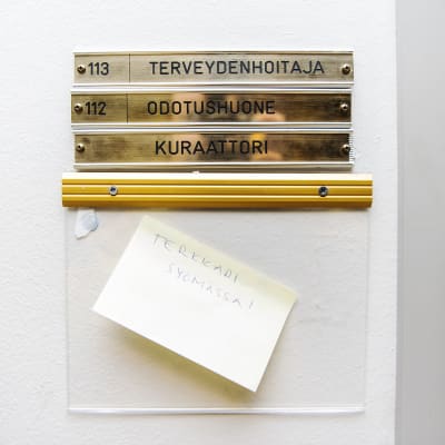 Kuvassa on kyltti, jossa lukee terveydenhoitaja ja kuraattori.