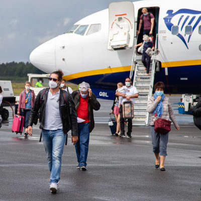 Italiasta tulleita ihmisiä kasvomaskeissa kävelee lentokoneesta Lappeenrannan lentoasemalla 1.7.2020.