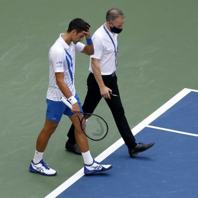 Novak Djokovic lämnar tennisplanen efter att han slagit till en boll som träffade och skadade en linjedomare.