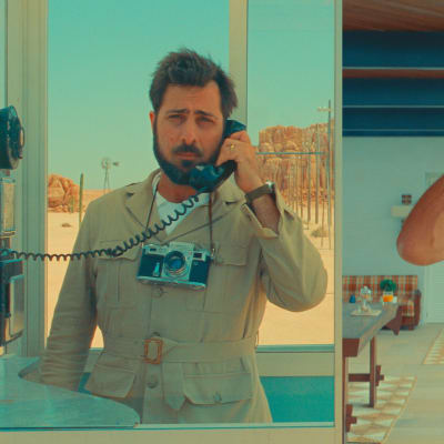Ihopklippt bild som låter oss se två män tala med varandra i telefon stående i helt olika miljöer.