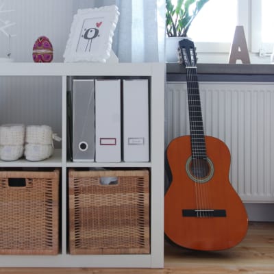 Bild på en bostad med en hylla och en gitarr.
