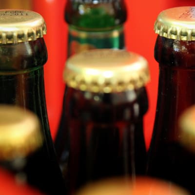 Närbild på bruna glasölflaskor med mässingsfärgade kapsyler.