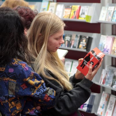 Unga är också intresserade av ljudböcker. Två ungdomar granskar en ljudbok i butikshyllan.