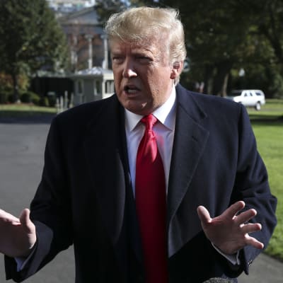 Donald Trump möter pressen utanför vita huset. Han håller upp sina händer mot kameran.