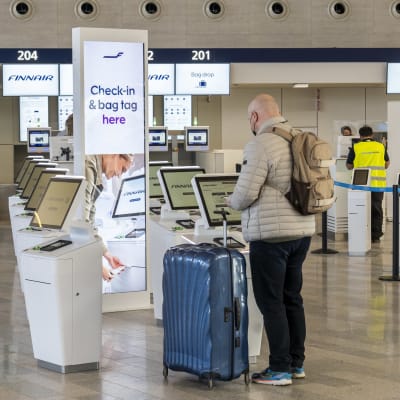 Helsinki-Vantaan lentoasema, uusi terminaali, matkustajia Finnairin itsepalvelu lähtöselvityksessä.