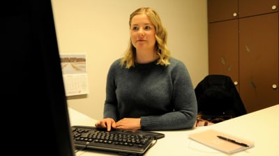 Kommunal tjänsteman sitter vid datorn i sitt arbetsrum