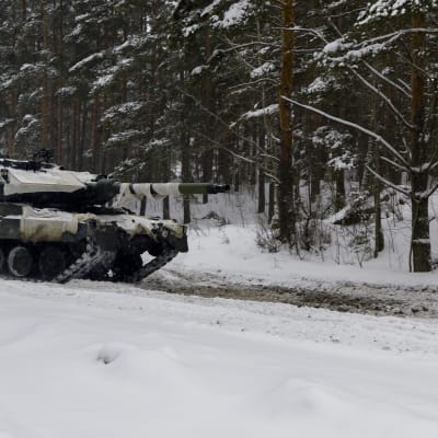 En stridsvagn i en snöig skog.