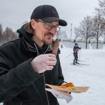 Aleksi Kärkkäinen ja Mari Karjalainen maistavat lihavartaita hiihtoladun varressa.