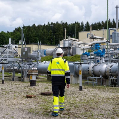 Uniperin työntekijä kulkee kaasuputkien luona selkä kameraan päin.