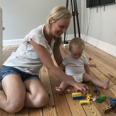 Karin Hafstad bygger med klossar på golvet med sin 1-åriga son.
