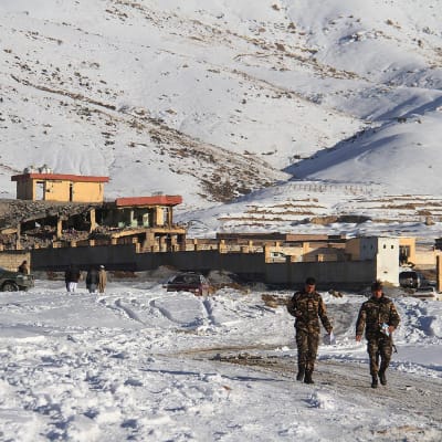 Afghanska säkerhetsstyrkor går nära militärbasen, där en bilbomb har exploderat.