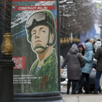 Bild från St. Petersburg som visar människor på gatan och en affisch för att gå med som kontraktsoldat i armén. 
