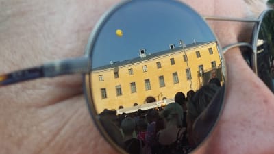 Gamla Akademihuset och en storbildsskärm med Bonnie Tyler syns i ett par solglasögon under musikfestivalen Down By The Laituri 2019 i Åbo.