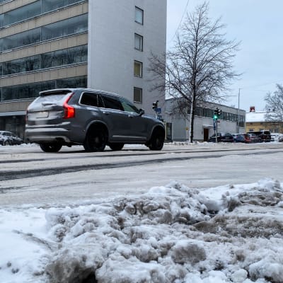 Auto ajaa Turun keskustassa lumisella tiellä.