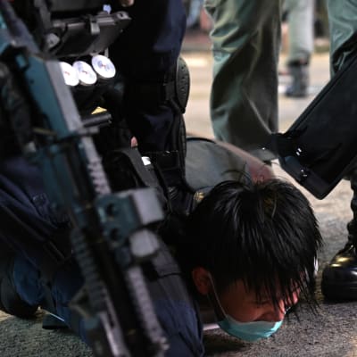 Poliisi taltuttamassa mielenosoittajaa Hongkongissa heinäkuussa. Hongkongilaiset aktivistit 