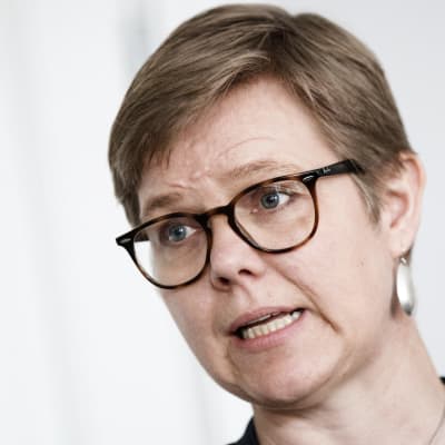 En närbild på Krista Mikkonen med glasögon och stora silverörhängen.