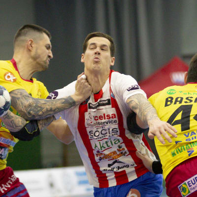 Nico Rönnberg försöker tränga sig förbi två Cocks-spelare.