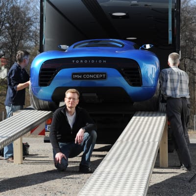 Pasi Pennanen poserar under sin superelbil Toroidion som rullas ut ur en transportbil.