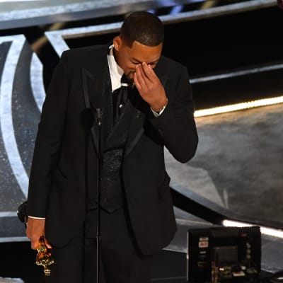 Will Smith håller handen för ögonen på Oscarsgalan.