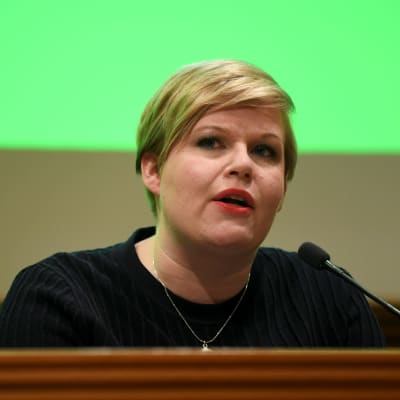 Annika Saarikko framför en liten mikrofon.