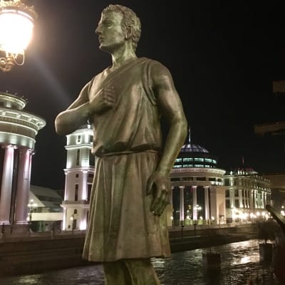 En ny staty på en av broarna över floden Vardar i Makedoniens huvudstad Skopje föreställer en soldat från Alexander den stores armé som håller handen mot hjärtat på ett patriotiskt sätt