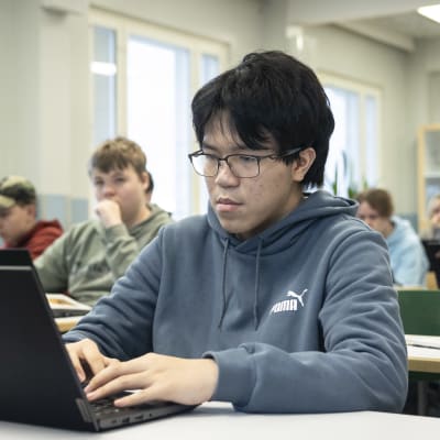 An Pham Sy kirjoittaa kannettavalla tietokoneella luokassa. 