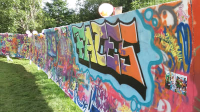 En grafittivägg där det står Faces med färggranna bokstäver.