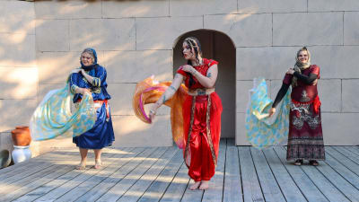 Tre personer dansar på en utomhusscen på Lurens sommarteater. 