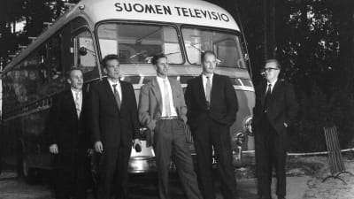 Suomen television auto, äänitysauto, jonka edessä seisoo viisi meistä, henkilöä. Tuntemattomia henkilöitä.