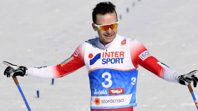 Sjur Röthe sträcker ut händerna i en segergest efter sin målgång  i VM.s skiathlon.
