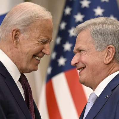 Joe Biden ja Sauli Niinistö hymyilevät, kun he katsovat toisiaan.