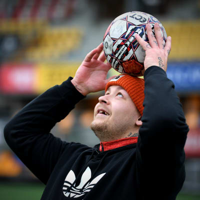 Pele Koljonen kannattelee palloa päänsä päällä.