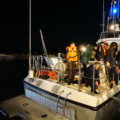 Merestä pelastettuja turvapaikanhakijoita kuljettava alus saapuu satamaan.