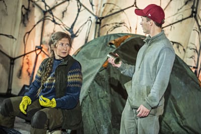 Skådespelarna Carla Fri och Jakob Johansson står på scenen framför ett tält. De spelar med i Wasa Teaters föreställning Glänta.