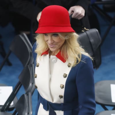 Kellyanne Conway är klädd i en stor röd filthatt och har en blåvitröd kappa med knappar formade som kattdjur.