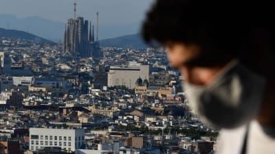 En man i ansiktsmask. I bakgrunden syns katedralen Sagrada Familia