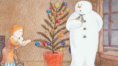 Pojken  och snögubben står vid en julgran i en scen från den tecknade filmen Snögubben.