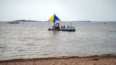Flera personer jobbar på en vattenkarusell i havet. 