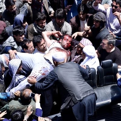 Afghanska demonstranter bär bort en skadad man i Kabul 2.6.2017.