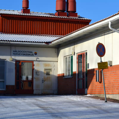 Bild på Ingå hälsostation utifrån. Ett vitt och tegelrött hus.