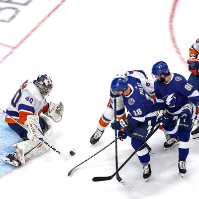 Ondrej Palat och Nikita Kutjerov i Tampa Bay försöker stöta in pucken framför Sergej Varlamov i New York Islanders-målet.
