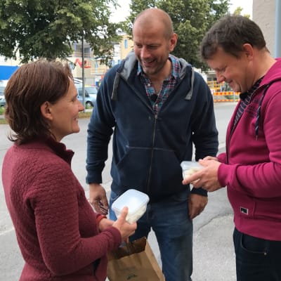 Shanti Paz Limnell står med en låda fetaost i handen invid Matias Jungar och Michael Björklund.