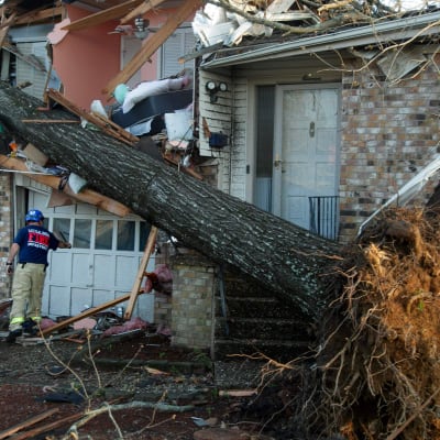 En brandman granskar hem i området Walnut Ridge efter att en tornado skadat hundratals hem och byggnader.