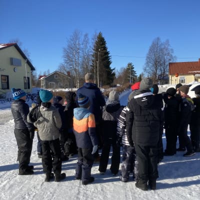 Joukko lapsia koulun pihalla Merijärvellä.